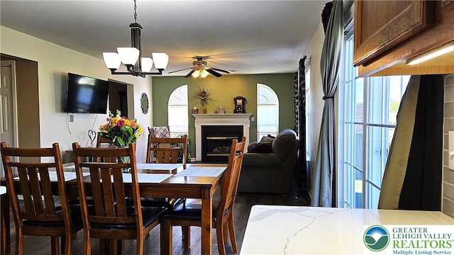 4125 Redbud Dr W, Whitehall Twp, PA 18052 - dining area featuring wood finished floors, a fireplace, a chandelier, and a ceiling fan