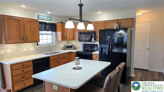 4125 Redbud Dr W, Whitehall Twp, PA 18052 - kitchen featuring black appliances, a sink, brown cabinetry, a kitchen island, and backsplash