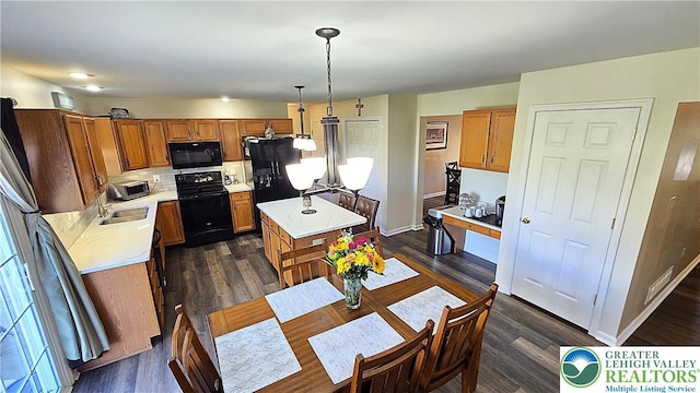 4125 Redbud Dr W, Whitehall Twp, PA 18052 - kitchen with black appliances, a center island, a sink, light countertops, and brown cabinets