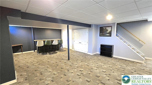 4125 Redbud Dr W, Whitehall Twp, PA 18052 - finished below grade area with a paneled ceiling, a bar, stairway, baseboards, and brick patterned floors