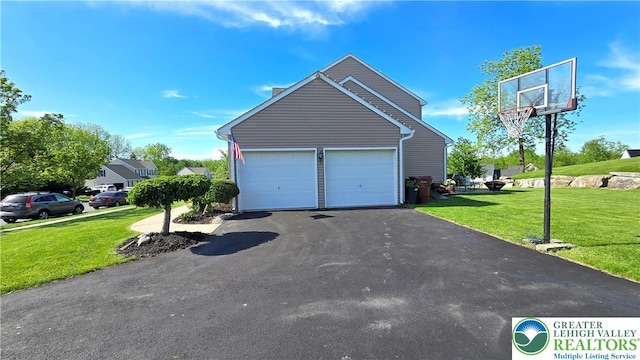 4125 Redbud Dr W, Whitehall Twp, PA 18052 - view of side of property featuring asphalt driveway, a lawn, an attached garage, and a chimney