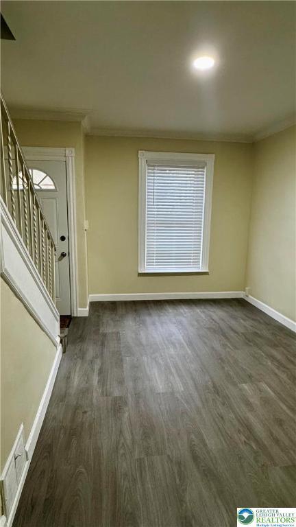 836 Elliger St, Allentown City, PA 18102 - empty room featuring dark wood finished floors, baseboards, crown molding, and stairs
