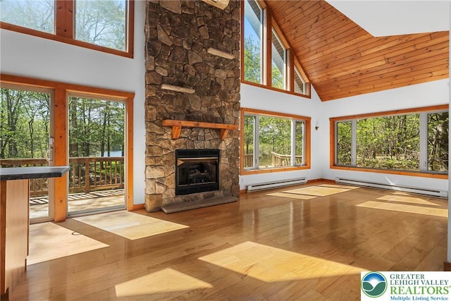 2107 Lenape Ter, Barrett Twp, PA 18325 - unfurnished living room with baseboard heating, high vaulted ceiling, a stone fireplace, hardwood / wood-style flooring, and wooden ceiling