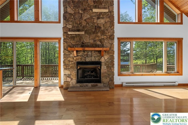 2107 Lenape Ter, Barrett Twp, PA 18325 - unfurnished living room with a baseboard radiator, plenty of natural light, wood finished floors, and high vaulted ceiling