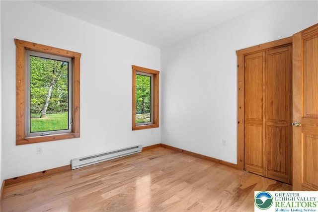 2107 Lenape Ter, Barrett Twp, PA 18325 - unfurnished bedroom with a baseboard heating unit, light wood-style flooring, and baseboards