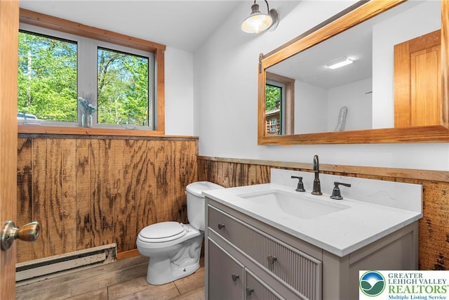 2107 Lenape Ter, Barrett Twp, PA 18325 - half bathroom featuring a baseboard heating unit, vanity, wainscoting, toilet, and wood finished floors