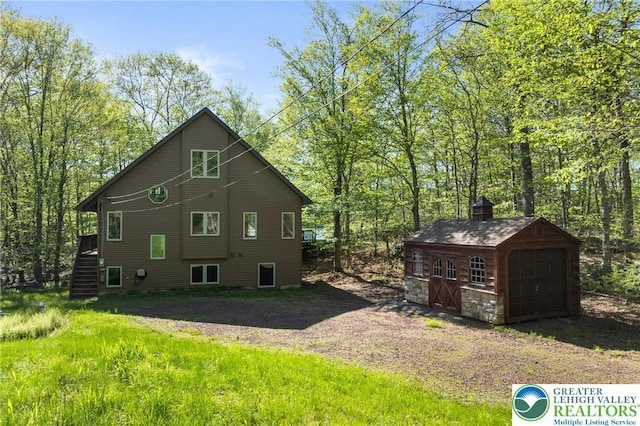 2107 Lenape Ter, Barrett Twp, PA 18325 - view of property exterior featuring an outdoor structure, a detached garage, and stairs