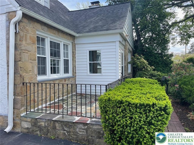 1123 Cumberland Rd, Abington, PA 19001 - view of side of property featuring a shingled roof, stone siding, and a chimney