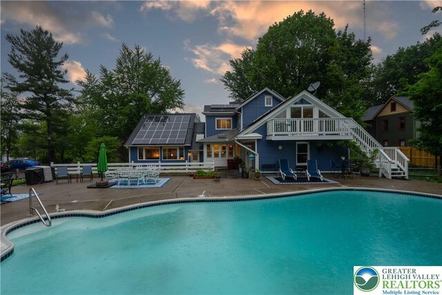 306 W Paxinosa Rd, Forks Twp, PA 18040 - pool at dusk with a patio area, stairway, and a deck