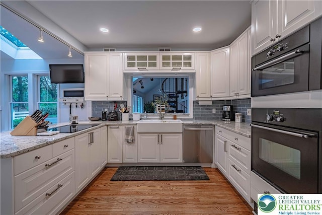 306 W Paxinosa Rd, Forks Twp, PA 18040 - kitchen with black appliances, a sink, white cabinets, light wood-type flooring, and recessed lighting