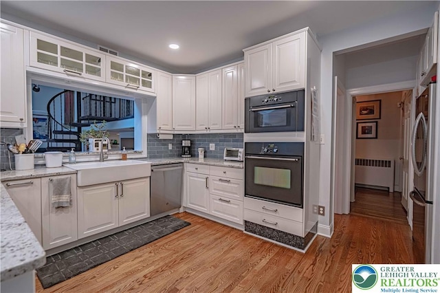 306 W Paxinosa Rd, Forks Twp, PA 18040 - kitchen featuring radiator, stainless steel appliances, a sink, white cabinets, and recessed lighting