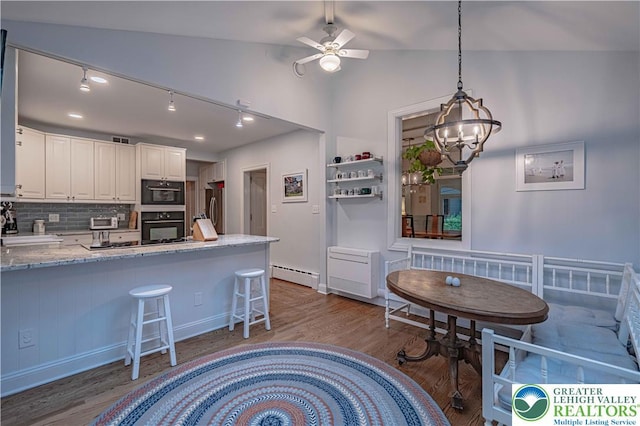 306 W Paxinosa Rd, Forks Twp, PA 18040 - kitchen with baseboard heating, oven, stainless steel refrigerator, wood finished floors, and tasteful backsplash