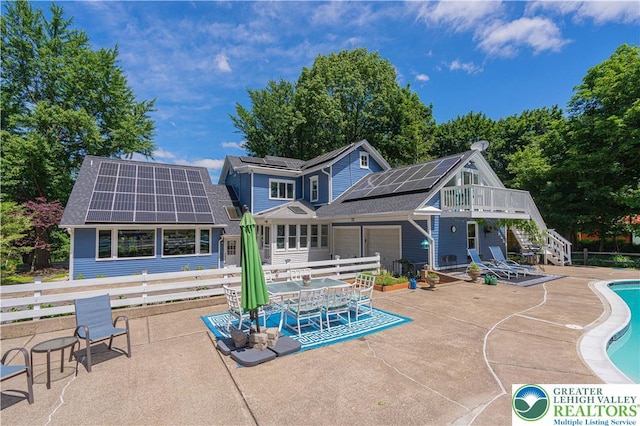 306 W Paxinosa Rd, Forks Twp, PA 18040 - back of property with roof mounted solar panels, a patio, an outdoor pool, roof with shingles, and stairway