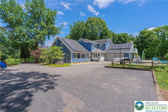 306 W Paxinosa Rd, Forks Twp, PA 18040 - view of front facade featuring solar panels, an attached garage, driveway, and a pool