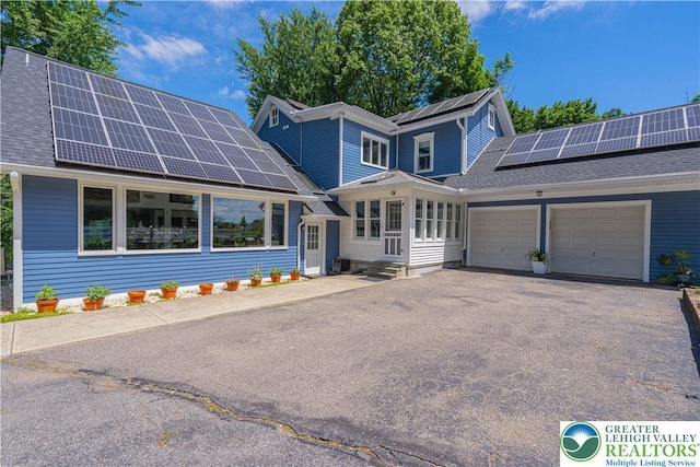 306 W Paxinosa Rd, Forks Twp, PA 18040 - traditional home with roof mounted solar panels, a garage, driveway, and roof with shingles