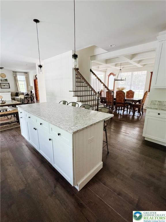 3183 Sheffield Dr, Lower Macungie Twp, PA 18049 - kitchen featuring dark wood-type flooring, open floor plan, white cabinets, light stone countertops, and a kitchen island