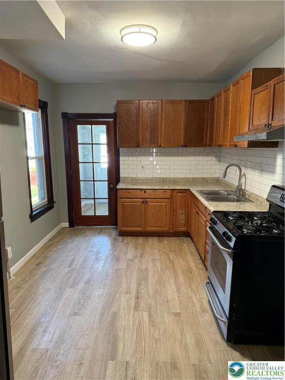 617 N 9th St, Allentown City, PA 18102 - kitchen featuring stainless steel gas range oven, a sink, under cabinet range hood, light countertops, and decorative backsplash