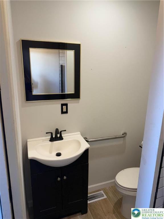 617 N 9th St, Allentown City, PA 18102 - bathroom featuring vanity, toilet, baseboards, and wood finished floors
