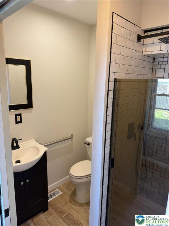 617 N 9th St, Allentown City, PA 18102 - full bath featuring a shower stall, vanity, toilet, and wood finished floors
