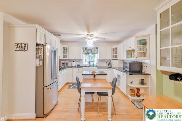 113 S Fairview St, Macungie Borough, PA 18062 - kitchen with stainless steel appliances, decorative backsplash, dark countertops, a ceiling fan, and light wood-type flooring