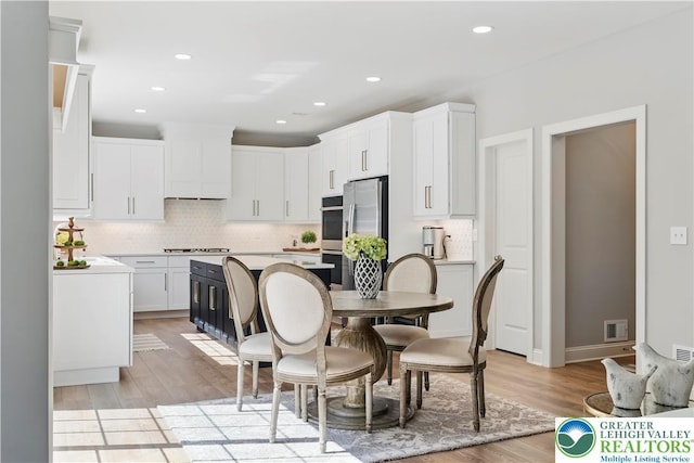 2638 Hollow View Dr, Forks Twp, PA 18040 - kitchen featuring tasteful backsplash, stainless steel appliances, light wood-style flooring, white cabinetry, and light countertops