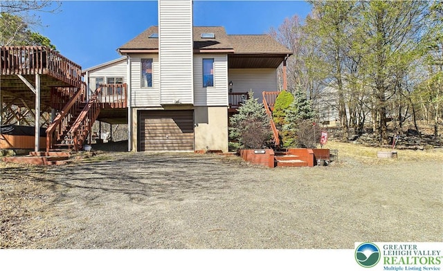 177 Dogwood Ter, Tunkhannock Township, PA 18210 - back of property with a deck, a chimney, stairway, an attached garage, and driveway