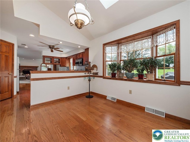 3840 E View Dr, North Whitehall Twp, PA 18069 - kitchen with stainless steel microwave, a peninsula, light wood-type flooring, vaulted ceiling, and recessed lighting