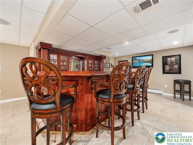 3840 E View Dr, North Whitehall Twp, PA 18069 - indoor bar featuring a baseboard heating unit, a drop ceiling, baseboards, and light tile patterned floors