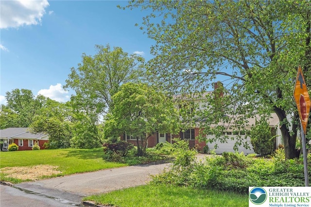 1450 Springhouse Rd, South Whitehall Twp, PA 18104 - view of property hidden behind natural elements featuring an attached garage, a front yard, and driveway
