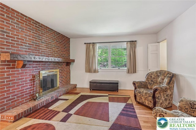1450 Springhouse Rd, South Whitehall Twp, PA 18104 - living area featuring wood finished floors, a brick fireplace, and wainscoting