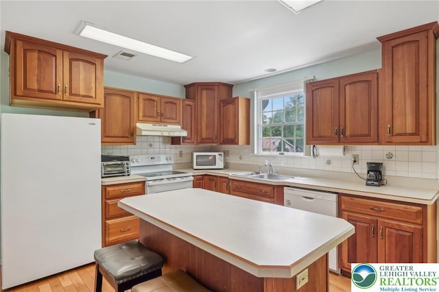 1450 Springhouse Rd, South Whitehall Twp, PA 18104 - kitchen featuring white appliances, a sink, under cabinet range hood, light countertops, and brown cabinetry