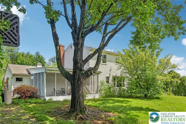 1450 Springhouse Rd, South Whitehall Twp, PA 18104 - view of home's exterior featuring a sunroom, a chimney, and a yard