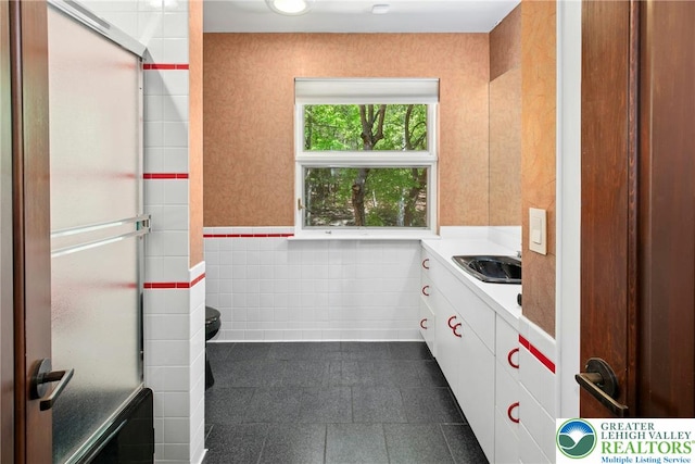 310 Hunters Farm Rd, Paradise Twp, PA 18332 - bathroom with tile walls, vanity, a stall shower, a wainscoted wall, and tile patterned flooring