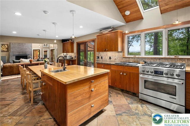 310 Hunters Farm Rd, Paradise Twp, PA 18332 - kitchen featuring high end range, a sink, stone tile floors, decorative backsplash, and butcher block counters