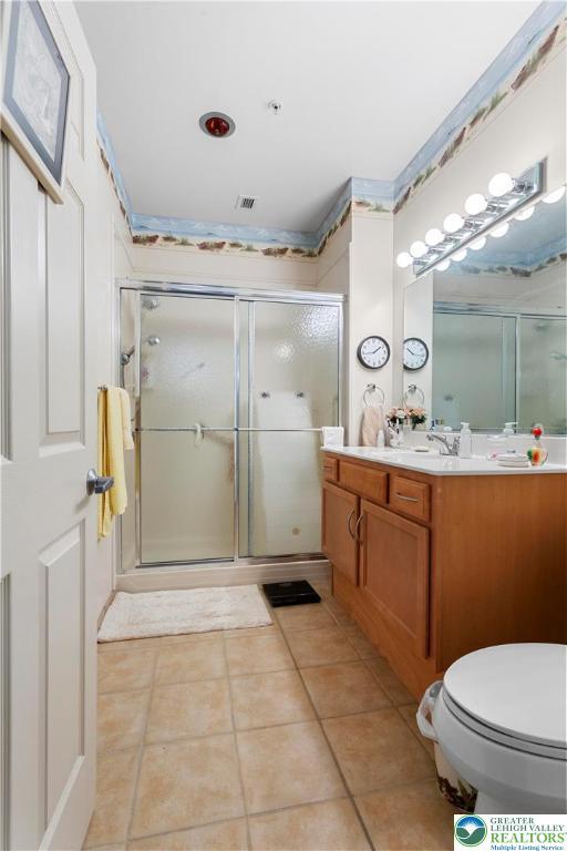 2121 Hokendauqua Ave Unit 210, Northampton Borough, PA 18067 - bathroom with vanity, a shower stall, toilet, and tile patterned floors
