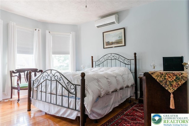 433 S 19th St, Easton, PA 18042 - bedroom with a wall mounted AC, hardwood / wood-style floors, and a textured ceiling