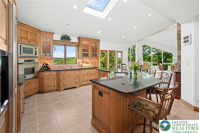 511 Center Hill Rd, Nockamixon Twp, PA 18972 - kitchen featuring appliances with stainless steel finishes, a kitchen bar, backsplash, dark countertops, and a sink