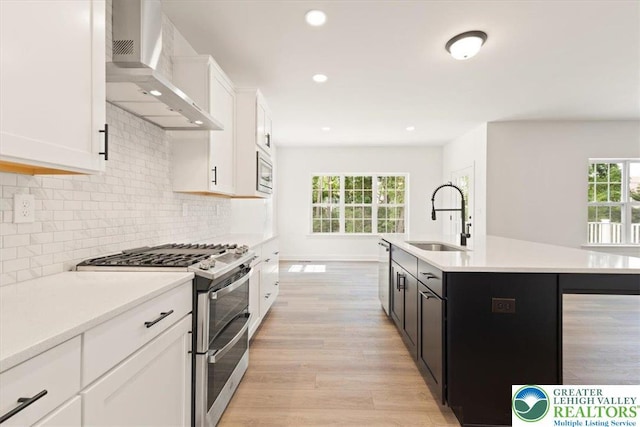 1350 Lorton Dr Unit 56, Forks Twp, PA 18040 - kitchen with stainless steel appliances, wall chimney range hood, a sink, light countertops, and light wood-type flooring