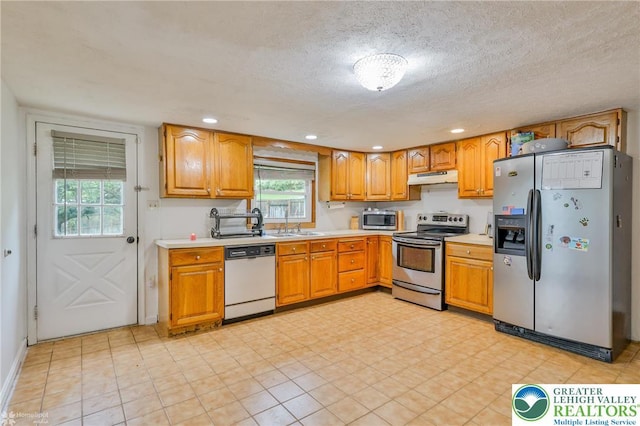 717 Frost Hollow Rd, Easton, PA 18040 - kitchen with appliances with stainless steel finishes, under cabinet range hood, light countertops, brown cabinetry, and recessed lighting