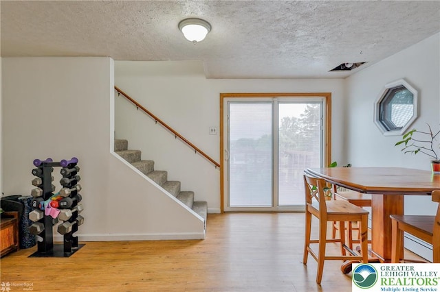717 Frost Hollow Rd, Easton, PA 18040 - dining area featuring a textured ceiling, light wood-type flooring, stairway, and baseboards
