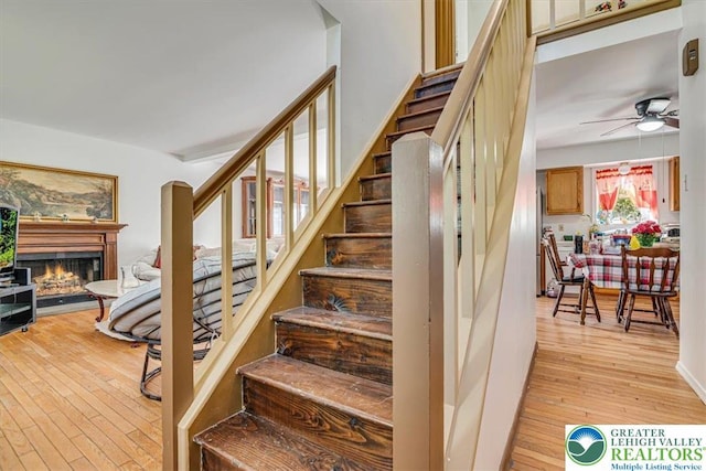 1281 Winding Way, Coolbaugh Twp, PA 18466 - stairs with hardwood / wood-style floors, ceiling fan, and a warm lit fireplace