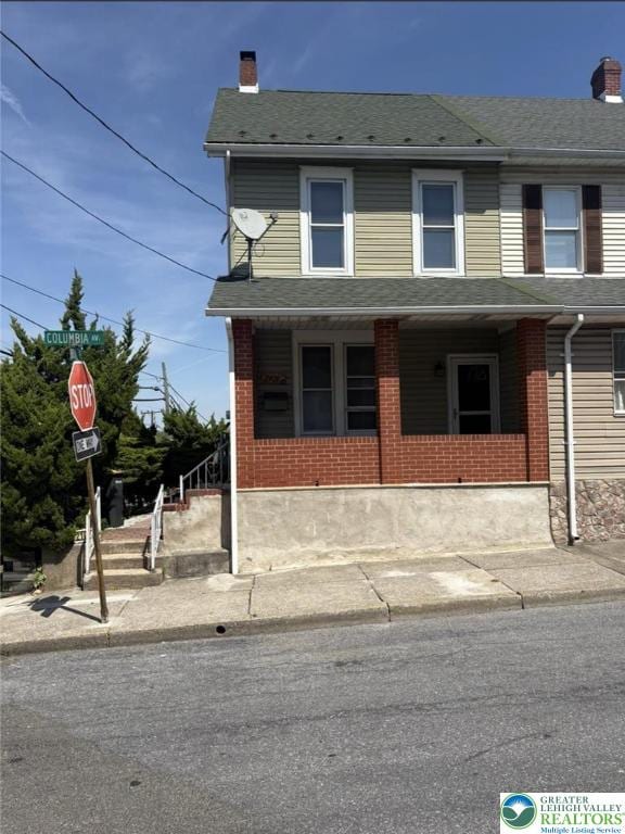 2101 Columbia Ave, Whitehall Twp, PA 18052 - view of property with a chimney, brick siding, covered porch, and roof with shingles
