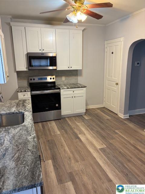 2101 Columbia Ave, Whitehall Twp, PA 18052 - kitchen with appliances with stainless steel finishes, arched walkways, a sink, white cabinetry, and crown molding