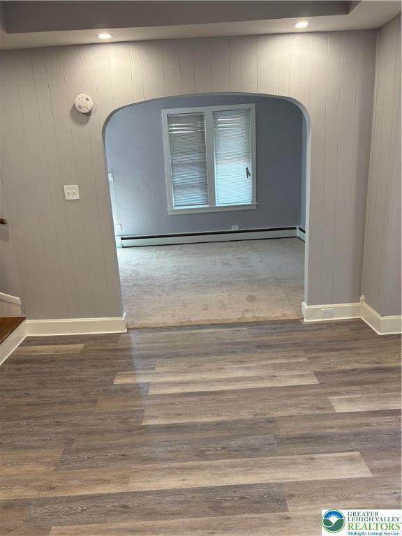 2101 Columbia Ave, Whitehall Twp, PA 18052 - empty room with arched walkways, wood finished floors, baseboards, and a baseboard heating unit