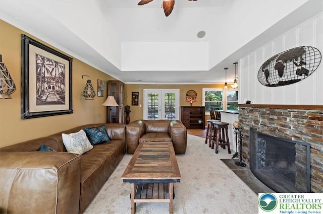 215 N Laurel Ln, West Whiteland Township, PA 19341 - living room featuring a ceiling fan, a stone fireplace, a raised ceiling, and crown molding