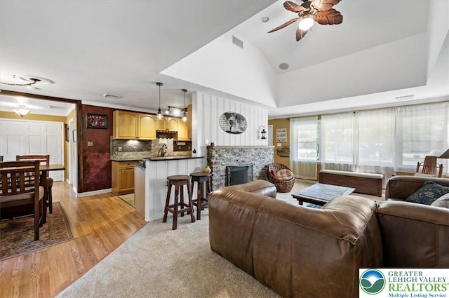 215 N Laurel Ln, West Whiteland Township, PA 19341 - living room with a ceiling fan, a stone fireplace, light wood-style floors, and lofted ceiling