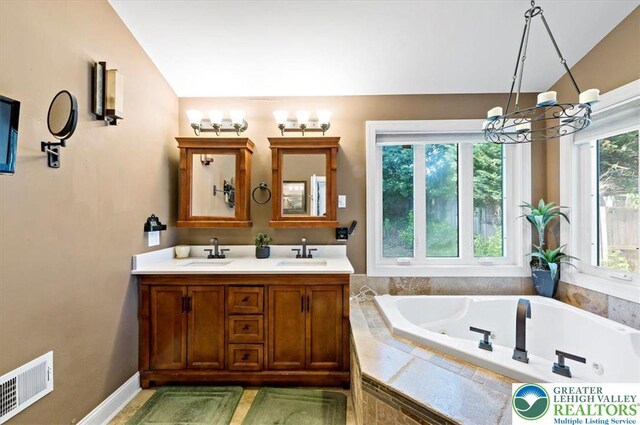 215 N Laurel Ln, West Whiteland Township, PA 19341 - full bathroom with vaulted ceiling, a tub with jets, double vanity, and a chandelier