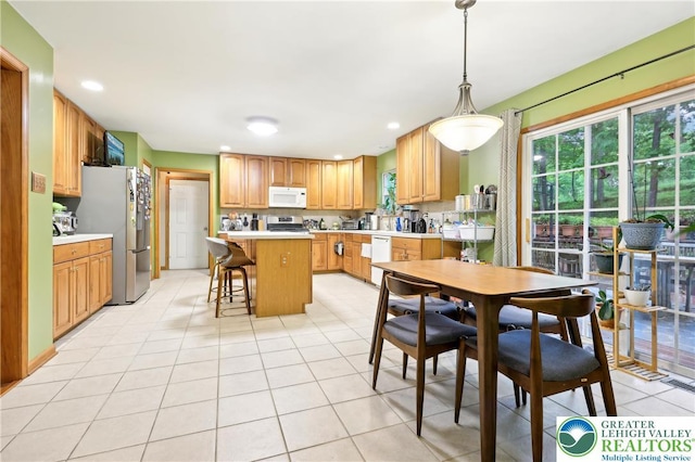 136 Outlook Ct, Middle Smithfield Twp, PA 18302 - kitchen with appliances with stainless steel finishes, light countertops, light tile patterned floors, a breakfast bar, and healthy amount of natural light
