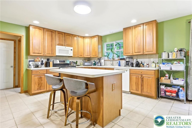 136 Outlook Ct, Middle Smithfield Twp, PA 18302 - kitchen with white appliances, light countertops, a center island, a kitchen breakfast bar, and recessed lighting