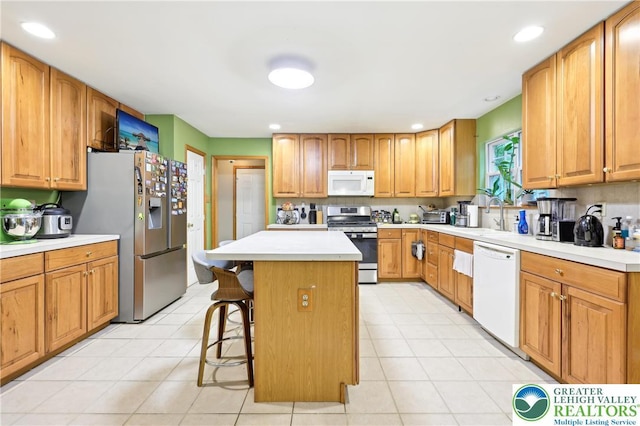 136 Outlook Ct, Middle Smithfield Twp, PA 18302 - kitchen with appliances with stainless steel finishes, a sink, a breakfast bar area, a center island, and light countertops